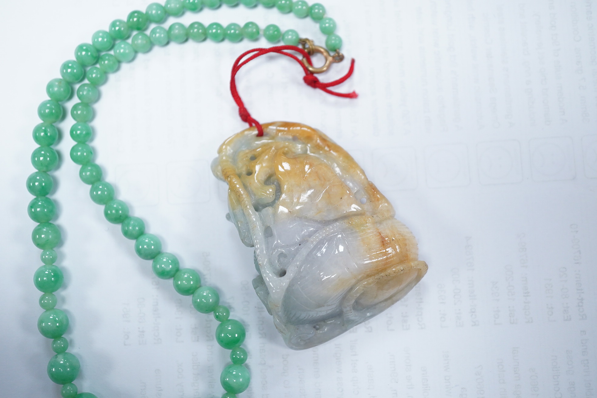 A Chinese jadeite carving and jadeite bead necklace, carving 6.5cm long. Condition - good